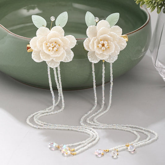 Horquillas con borlas largas y perlas de hojas y flores blancas